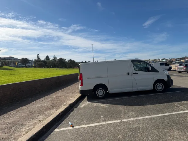 The parked Bondi Hot Water van in front of a beautiful beach